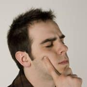 A man close his eyes and think hard