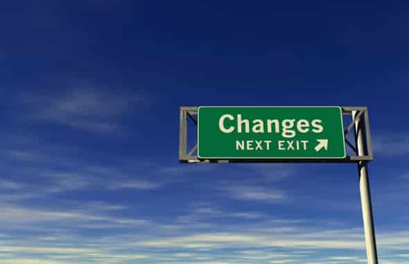 a green sign set against a blue sky, the sign says 'changes next left