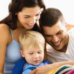 Caucasian parents and toddler son reading book.