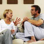 Couple taking to each other on sofa