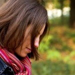 A young woman leaning against tree