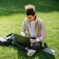 A man having online counselling in a park.